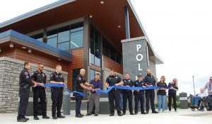 Police officers in uniform performing a ribbon-cutting ceremony for a new police station in Sauk Prairie, Wisconsin