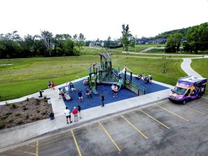 View of a new forest-themed playground  with children playing at Turtle Creek Park in Hiawatha Iowa