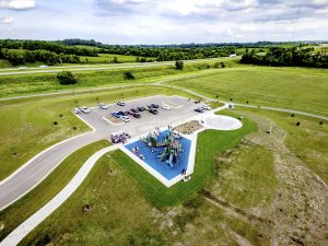 Aerial view of a new community playground and splash pad surrounded by rolling hills in Hiawatha, Iowa