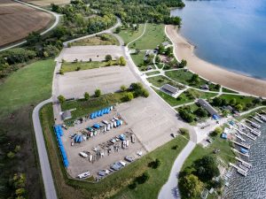 Aerial photograph of visitor parking lots at a state park in Iowa with cars and boats near a lake