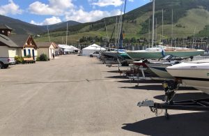 Marina service yard in Dillon Colorado showing boats on trailers and green mountains in the background.